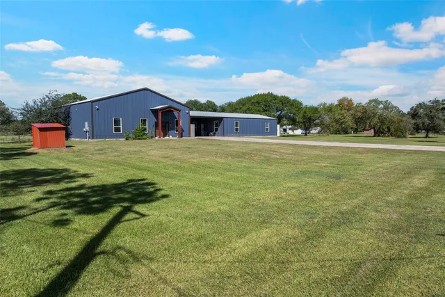 a front view of house with yard and trees in the background