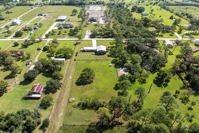 an aerial view of residential houses with outdoor space and trees