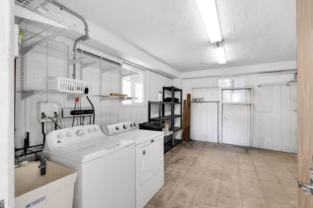 a view of a storage & utility room with fridge dryer and washer