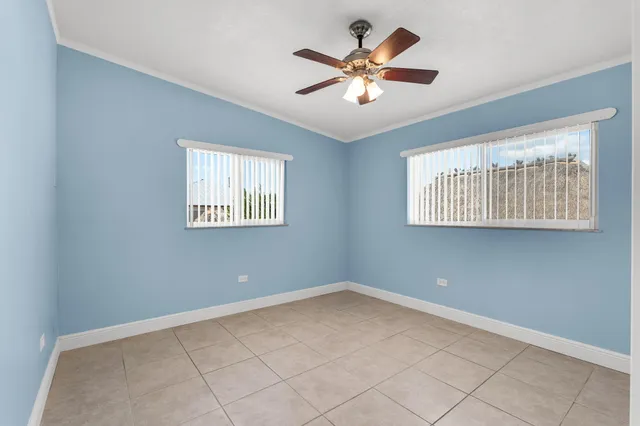 an empty room with closet and a ceiling fan