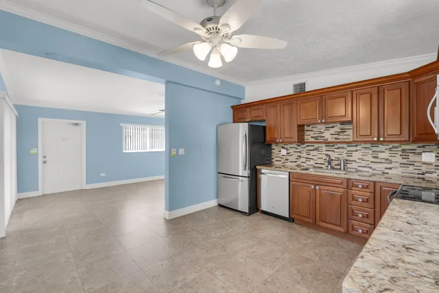 a kitchen with stainless steel appliances granite countertop a refrigerator sink and cabinets