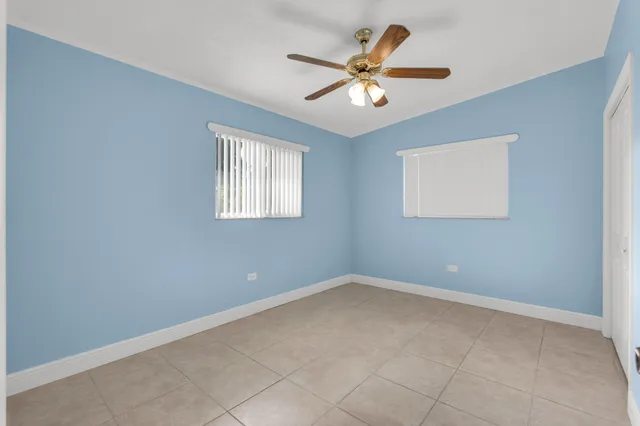 an empty room with windows and fan