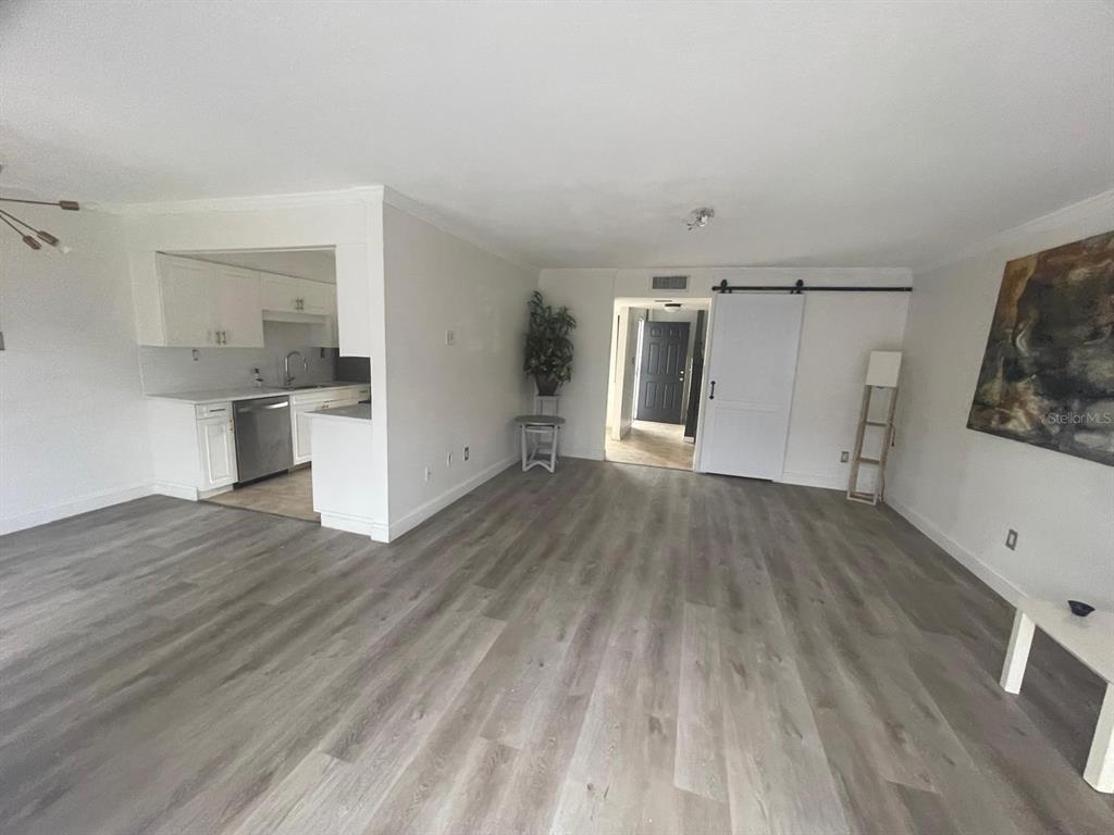 a view of a kitchen with wooden floor and a sink