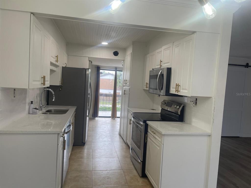 4559 Towerpine Road, Unit GE Orlando, FL 32839 - Photo 3 of 4 a kitchen with a refrigerator stove and sink