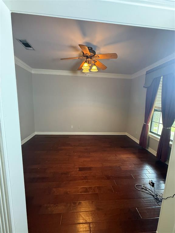 201 Woodhaven Drive Minden, LA 71055 - Photo 21 of 31 Spacious interior room featuring rich wood-finish flooring, crown molding, and a ceiling fan with integrated lighting