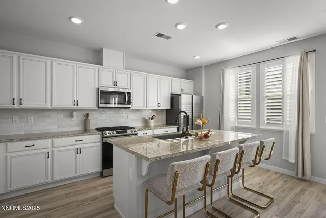 a kitchen with a stove a sink a dining table and chairs