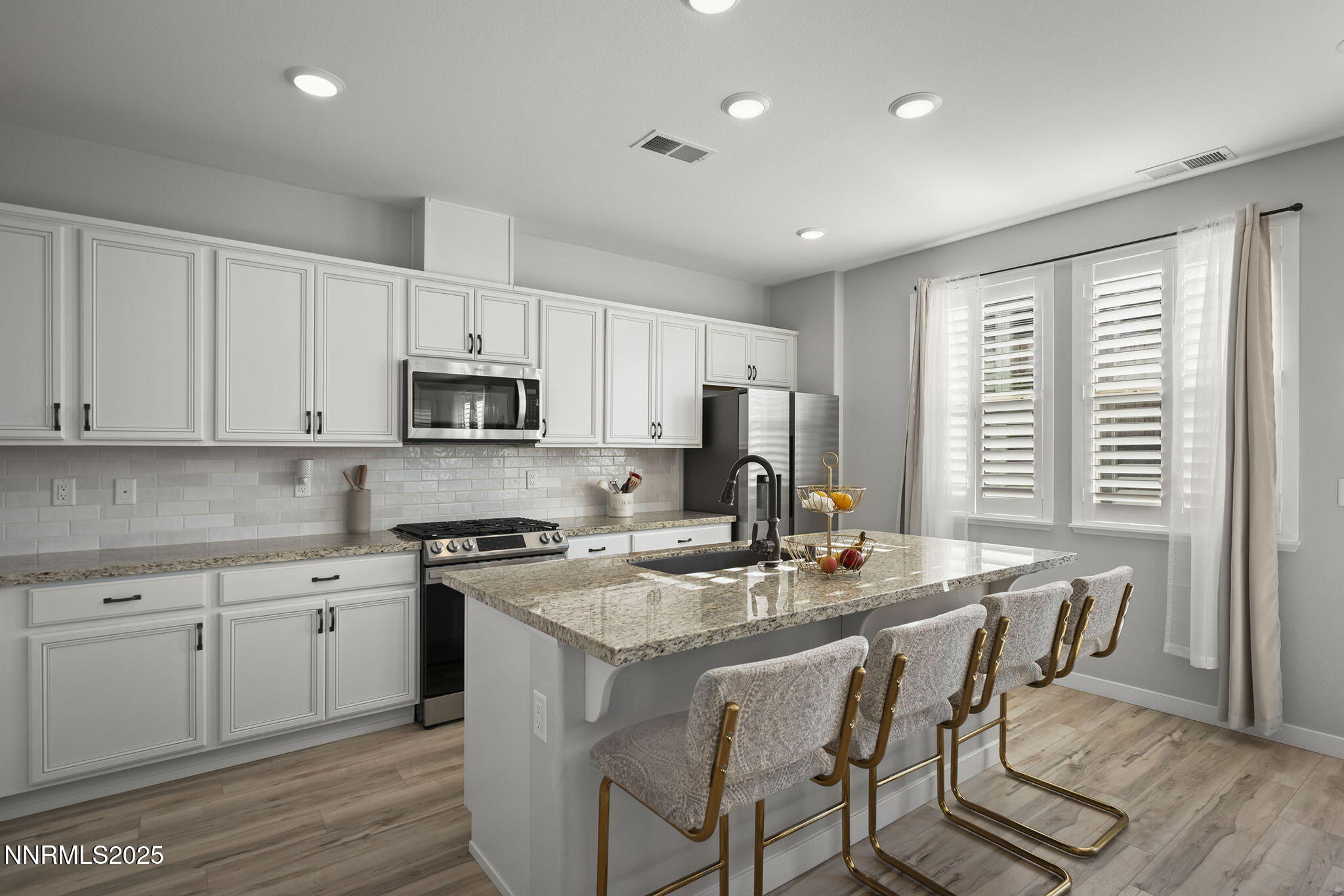7181 Mustengo Drive Reno, NV 89506 - Photo 3 of 37 a kitchen with a stove a sink a dining table and chairs