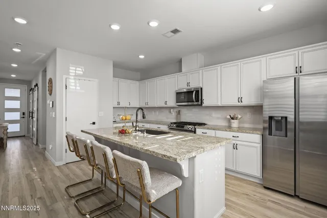 a kitchen with stainless steel appliances granite countertop a stove refrigerator sink and cabinets