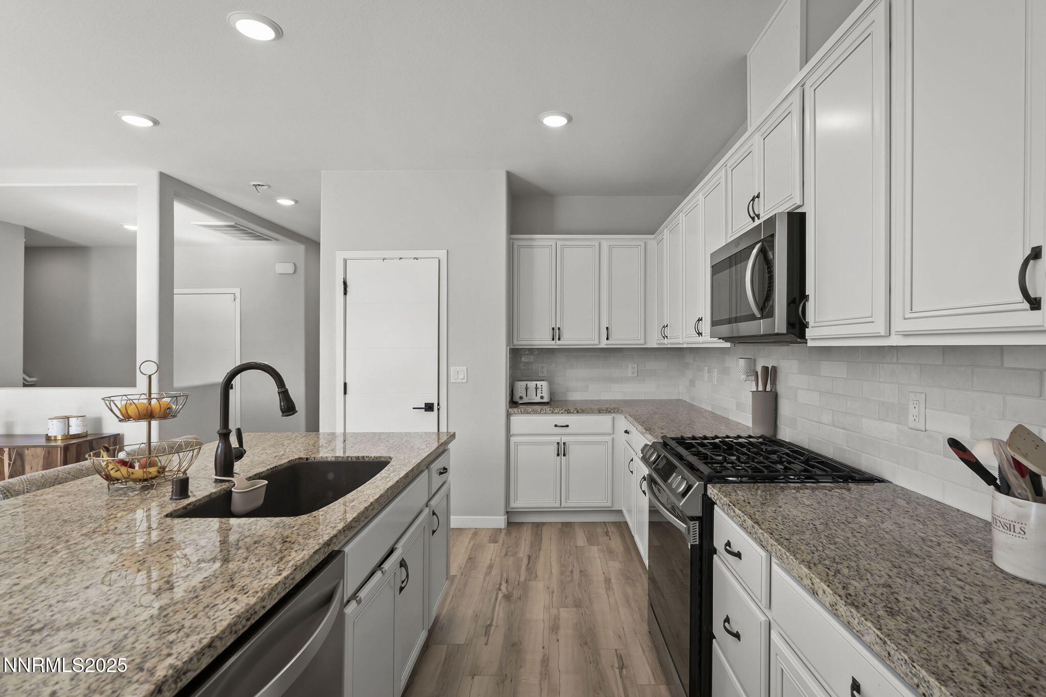 7181 Mustengo Drive Reno, NV 89506 - Photo 5 of 37 a kitchen with granite countertop a sink a stove and cabinets