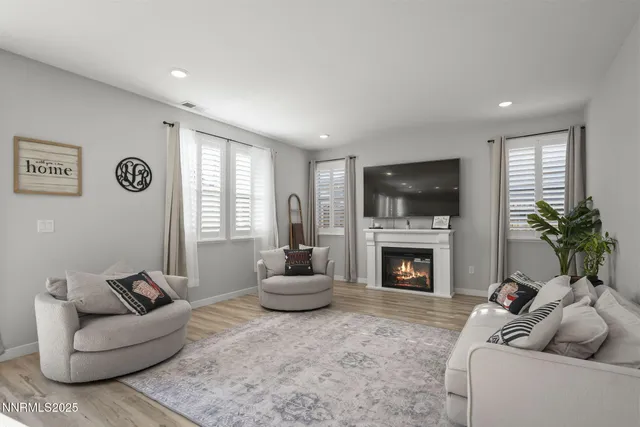 a living room with furniture a fireplace and a flat screen tv