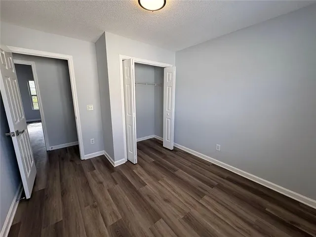an empty room with wooden floor and a mirror