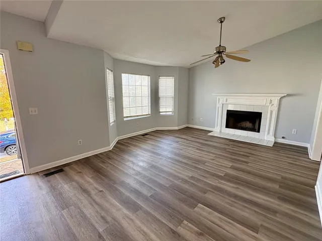 wooden floor fireplace and windows in an empty room