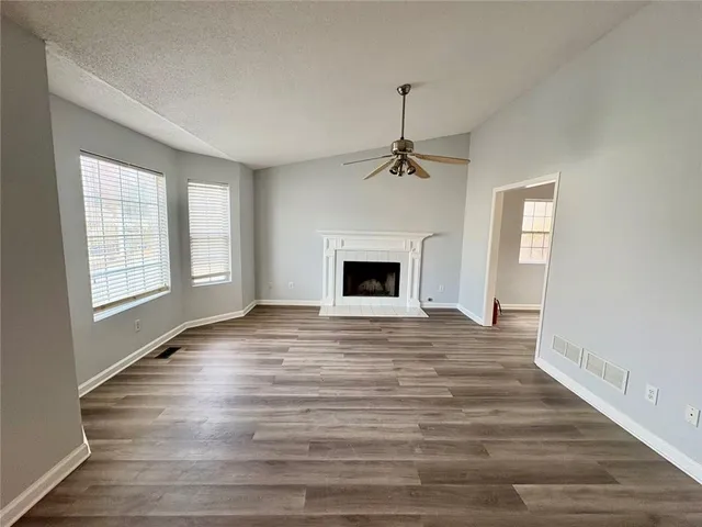 wooden floor fireplace and windows in an empty room