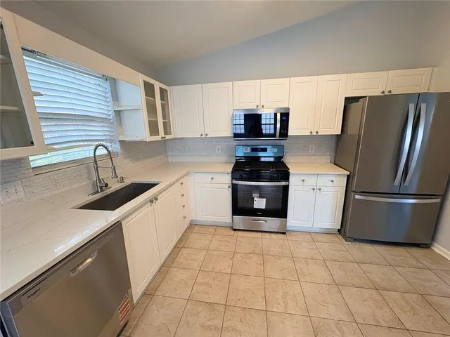 a kitchen with stainless steel appliances a refrigerator sink and microwave