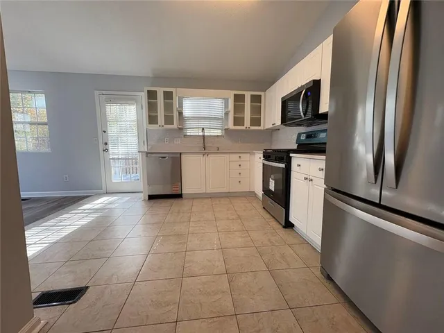 a kitchen with a refrigerator a stove top oven a sink dishwasher and a refrigerator