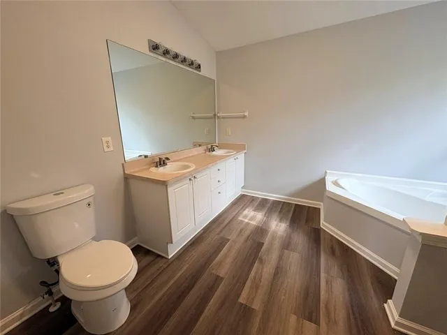 a bathroom with a granite countertop toilet sink and mirror