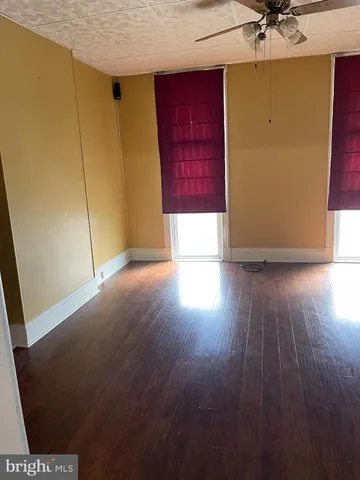 an empty room with wooden floor and cabinet