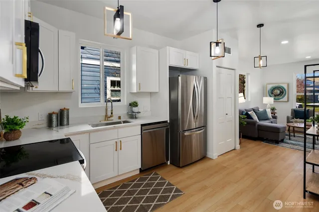 a kitchen with white cabinets stainless steel appliances and sink