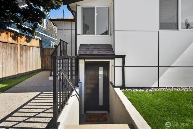 a view of a hallway with wooden floor and a bathroom