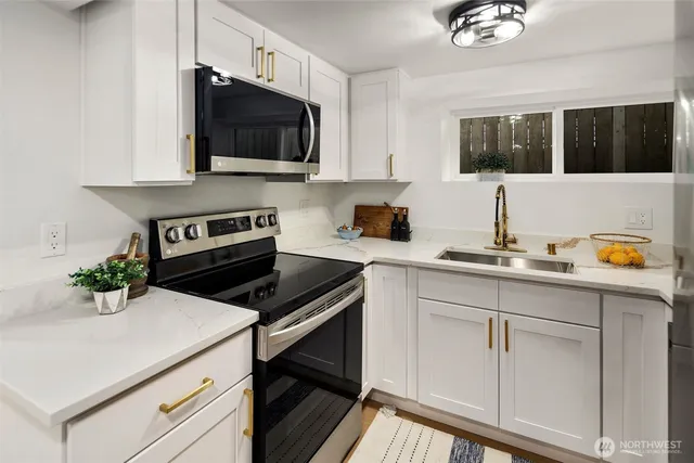 a kitchen with stainless steel appliances a refrigerator sink and white cabinets