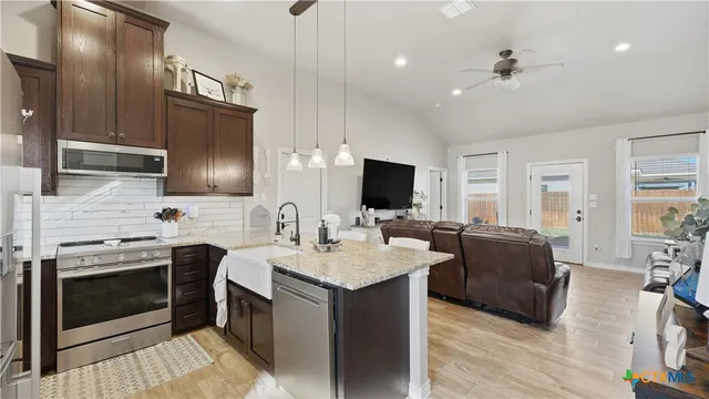 a kitchen with stainless steel appliances granite countertop a sink stove and refrigerator
