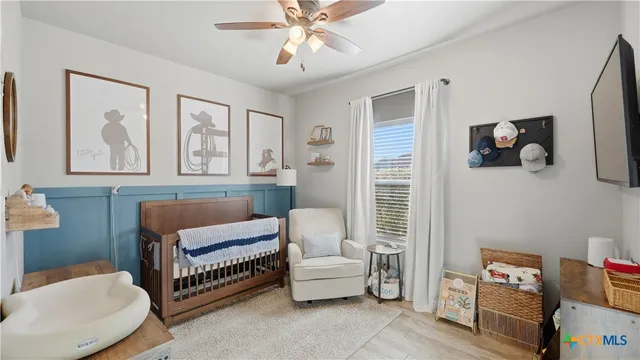 a living room with furniture and a baby crib