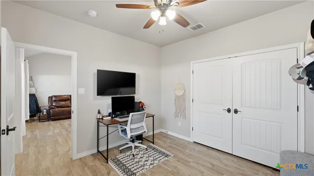 a view of a workspace with furniture and a window