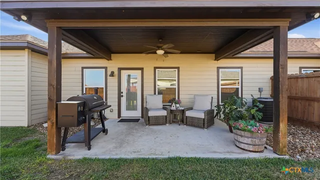 a view of a porch with chairs and potted plants
