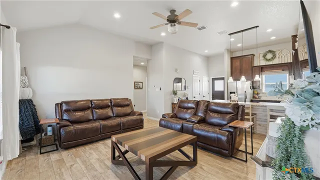 a living room with furniture and a wooden floor