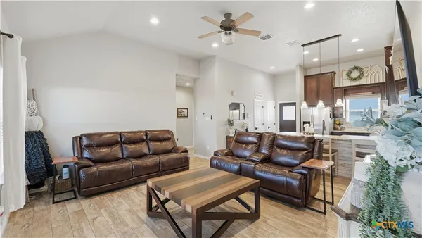 a living room with furniture and a wooden floor