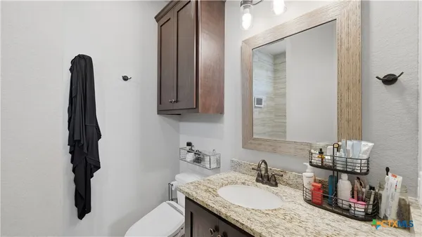 a bathroom with a granite countertop sink and a mirror