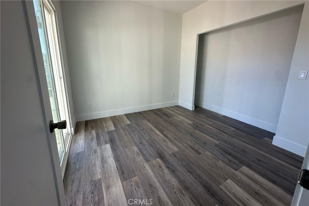 22113 Grand Terrace Road, Unit 16 Grand Terrace, CA 92313 - Photo 9 of 15 an empty room with wooden floor and a window