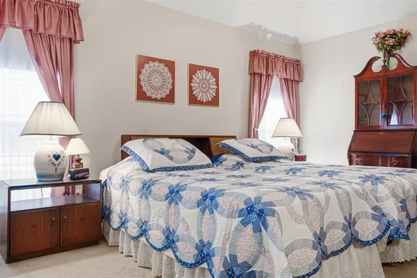 a bed sitting in a bedroom and a chandelier