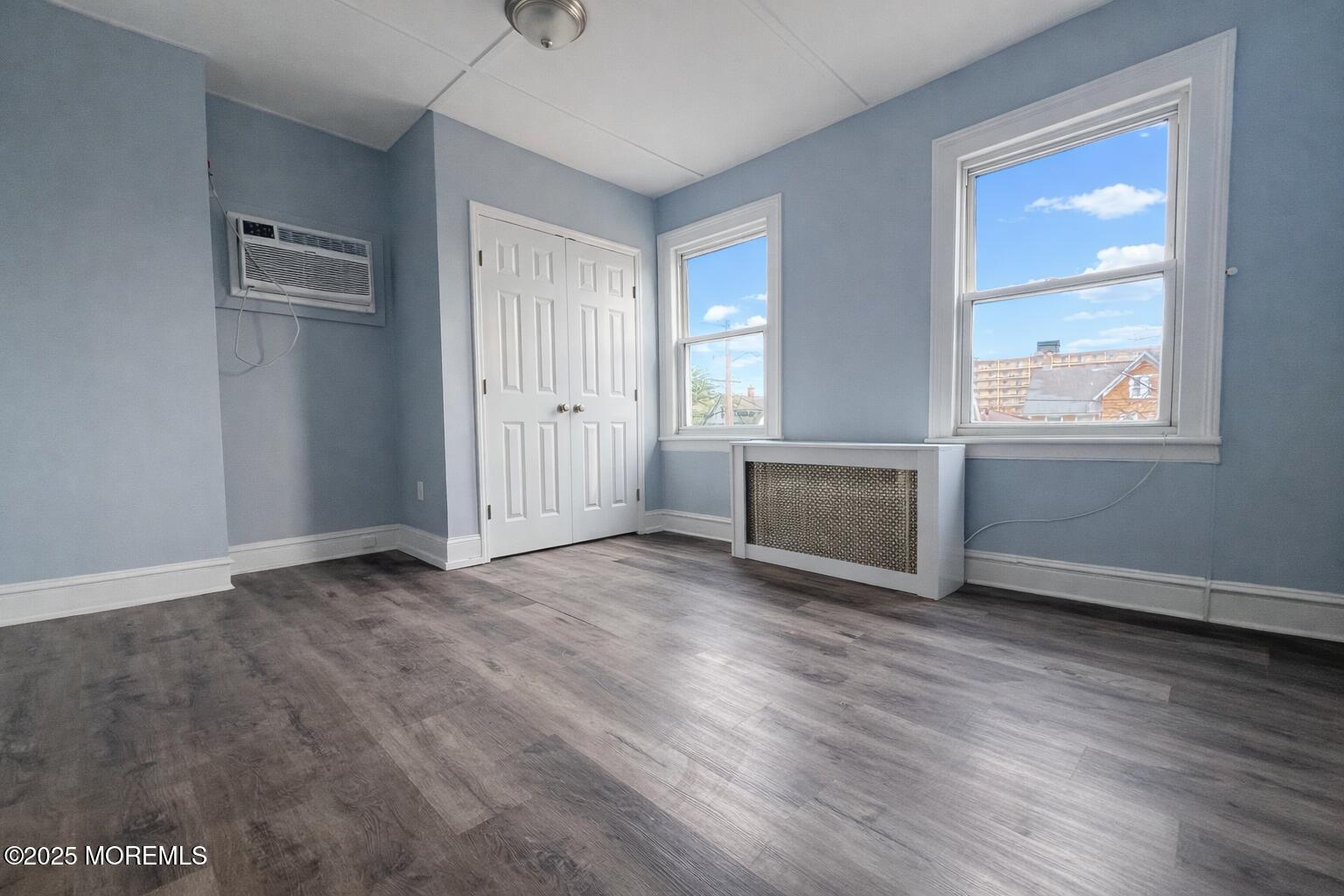 23 Rector Place, Unit B Red Bank, NJ 07701 - Photo 9 of 9 an empty room with wooden floor and windows