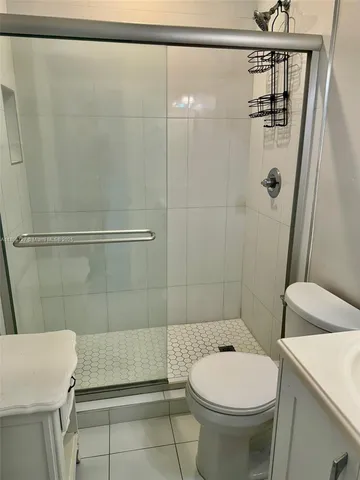 a bathroom with a shower a toilet and a sink