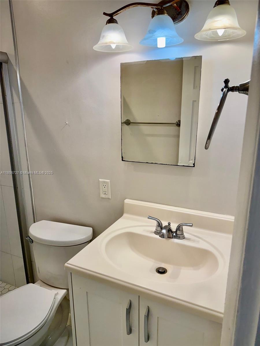 301 East McNab Road, Unit 205 Pompano Beach, FL 33060 - Photo 14 of 22 a bathroom with a sink a toilet and mirror