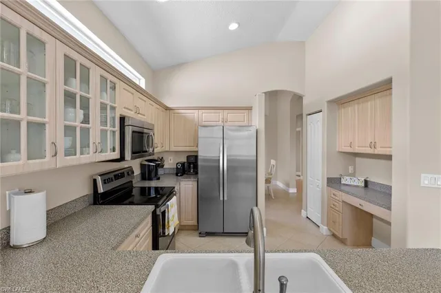 a kitchen with stainless steel appliances granite countertop a refrigerator and a stove top oven
