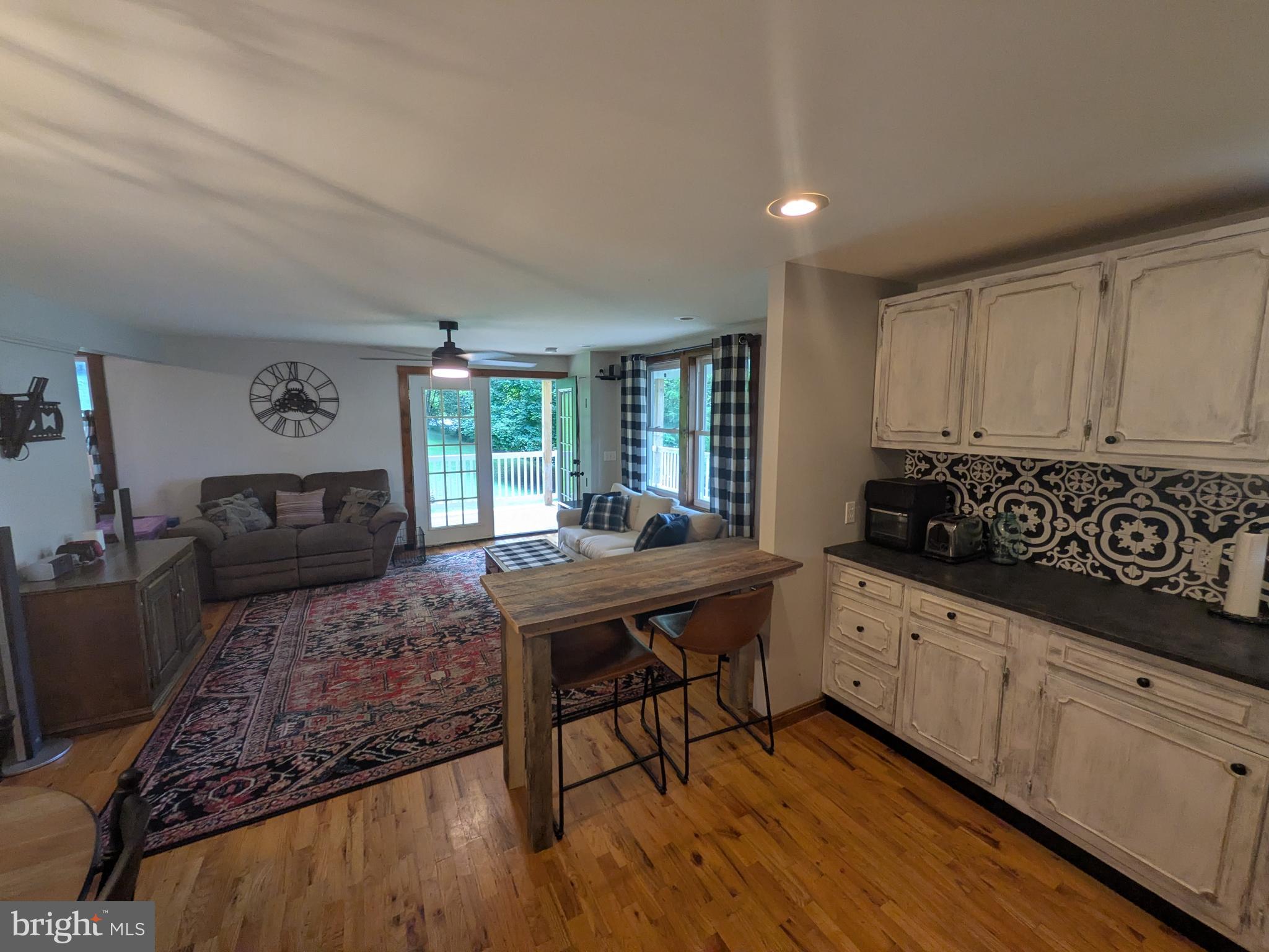2418 Muddy Run Road Mifflintown, PA 17059 - Photo 23 of 44 a kitchen with granite countertop a stove a sink and white cabinets with wooden floor