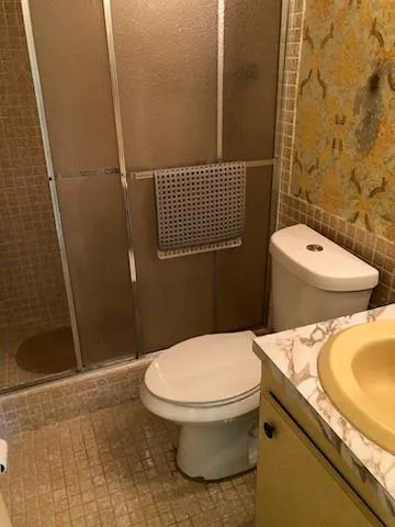 a bathroom with a toilet and a shower
