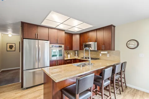 a kitchen with stainless steel appliances granite countertop a sink stove and cabinets