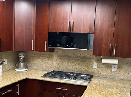a kitchen with stainless steel appliances a dining table and chairs