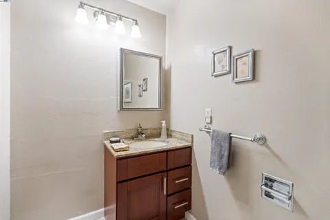 a bathroom with a granite countertop sink mirror vanity and toilet