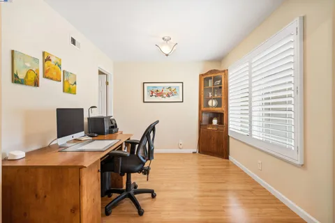 a kitchen with granite countertop a table chairs refrigerator and microwave