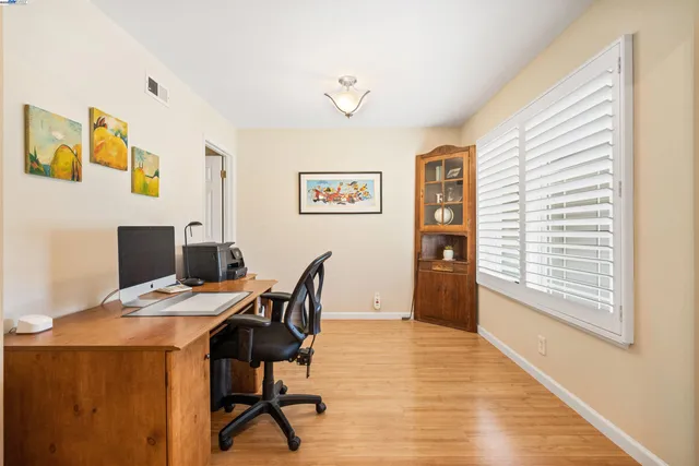 a kitchen with granite countertop a table chairs refrigerator and microwave