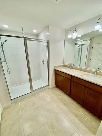 a bathroom with a double vanity sink a mirror and a bathtub