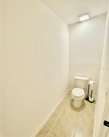 a white toilet sitting next to a white wall