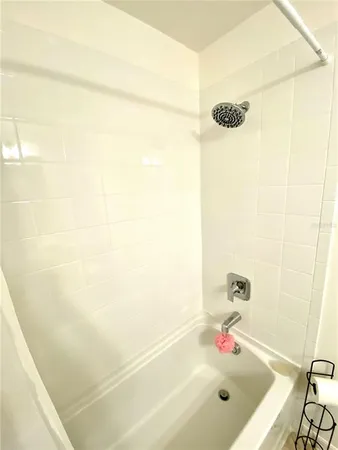 a bath tub sitting next to a white sink and a shower