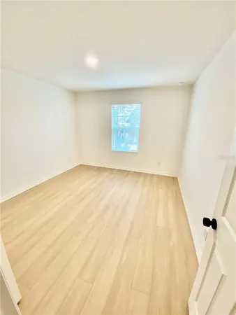 a view of a room with wooden floor and a ceiling fan