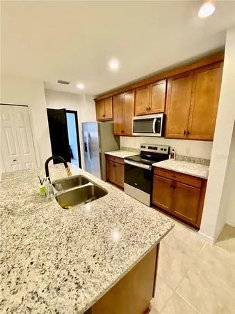 a kitchen with kitchen island sink stove and refrigerator