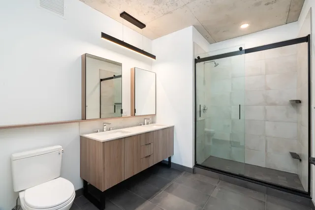 a bathroom with a double vanity sink toilet and shower